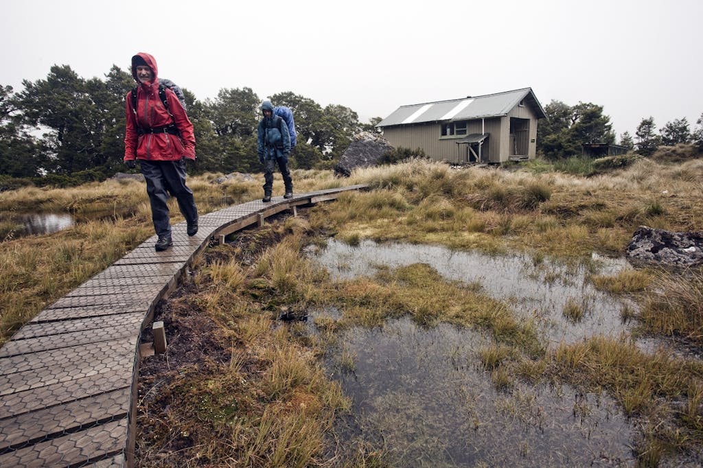 Trampers depart Lake Roe Hut for drier and warmer climes. Photo: Ray Salisbury