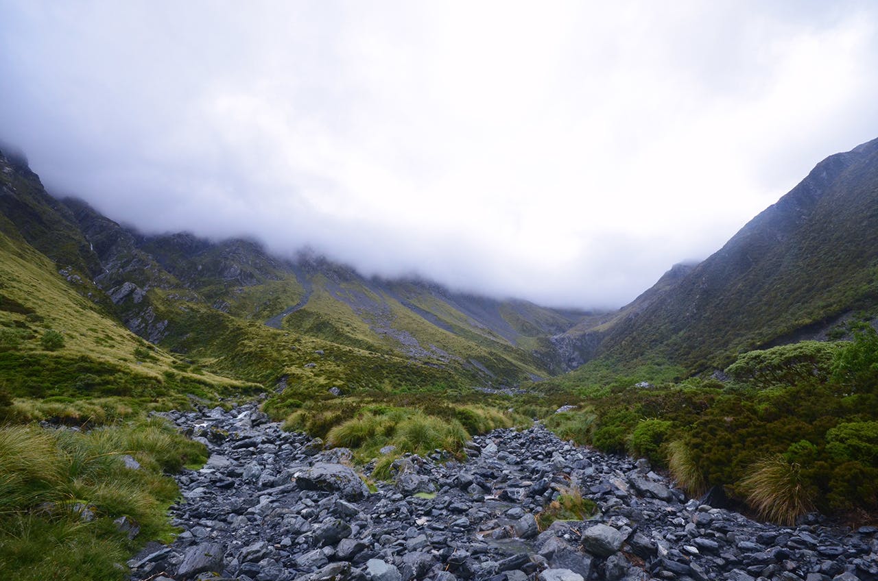Dark and menacing clouds, heavy with rain, gather at the head of the Arahura Valley. Photo: Ricky French