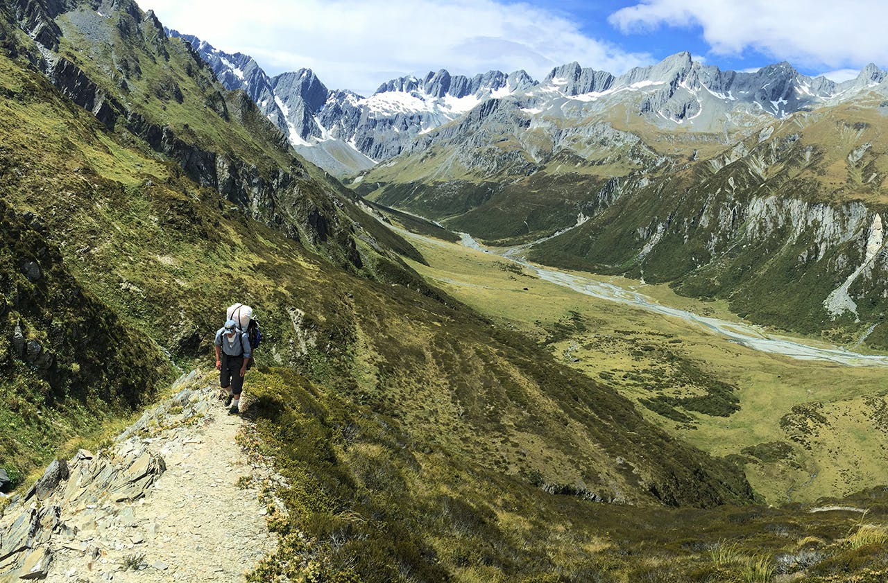 A packrafter carries his boat over Brodrick Pass. Photo: Thor Tingey