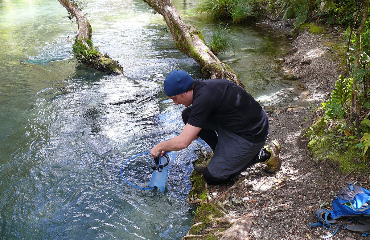 The author collects water from an area above the mills, where it is still safe to drink. Photo: Josh Gale