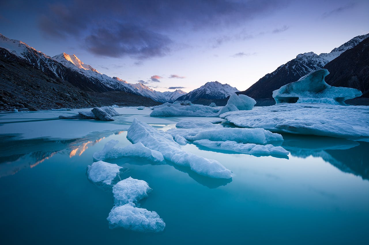 Melting glaciers create beautiful lakes like this at Tasman Glacier, but they also leave mounds of moraine which makes access to the mountains more difficult. Photo: Mark Watson