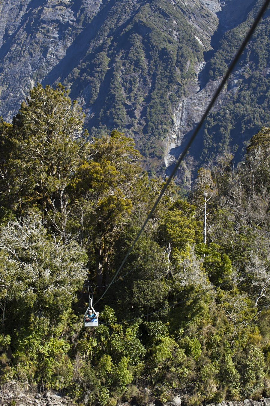 Hana Black crosses the cableway over the Karangarua River to access Regina Creek and the track to Conical Hill. Photo: Mark Watson