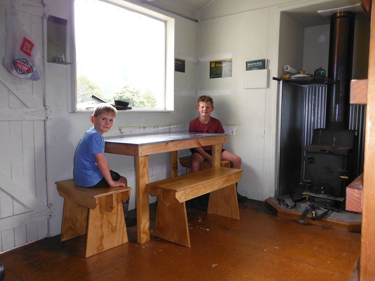 Enjoying the fruits of their labour - a seat at the hut's new bench. Photo: Supplied